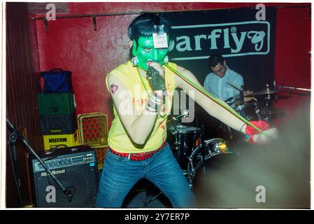 KAREN O, YEAH YEAH YEAHS, PREMIÈRE TOURNÉE britannique, 2002 : une jeune Karen O de Yeah Yeah Yeahs joue dans un film d'horreur Frankenstein masque jouant un petit concert en sueur lors de leur première tournée britannique au Barfly Club à Cardiff, au pays de Galles, Royaume-Uni le 21 avril 2002. Photo : Rob Watkins. NFO : Yeah Yeah Yeahs est un groupe de rock indépendant américain formé en 2000, connu pour son son art-punk énergique. Face à la chanteuse charismatique Karen O, ils ont gagné en renommée avec des tubes comme « Maps » et « Heads Will Roll », mêlant rock de garage brut à profondeur émotionnelle. Banque D'Images