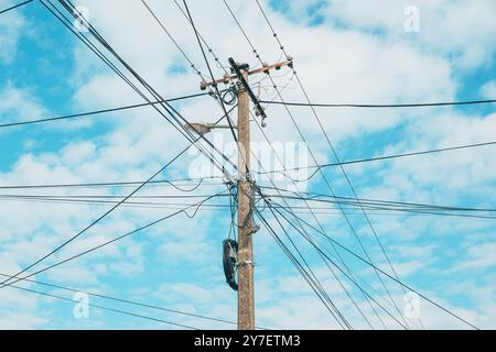 Poteau électrique en béton avec câbles et fils se répandant dans toutes les directions, vue à angle bas Banque D'Images