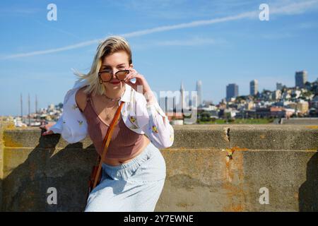 Jeune femme Standing Pier San Francisco Skyline fond Banque D'Images