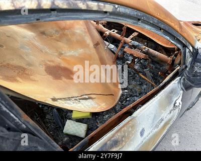 Les restes carbonisés d'un intérieur de voiture après un incendie. Le métal est rouillé et les sièges sont complètement détruits Banque D'Images