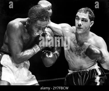 Le champion du monde poids lourds Rocky Marciano remporte le coup de poing qui a permis de protéger sa couronne et son titre en éliminant le Challenger Ezzard Charles après deux minutes et 36 secondes de la huitième manche de leur combat au Yankee Stadium, New York. 19 septembre 1954. Banque D'Images