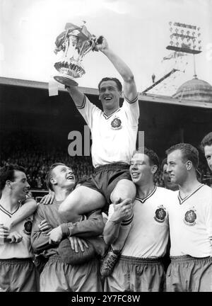 Finale de la FA Cup 1958 Manchester Utd V Bolton Wanderers la tenue de la FA Cup, qui vient de lui être présentée par le duc d'Édimbourg, l'attaquant central de Nat Lofthouse et capitaine de Bolton Wanderers, est présidée par ses coéquipiers après que Bolton eut battu Manchester Utd 2-0 en finale de la Coupe à Wembley. 3 mai 1958. Banque D'Images