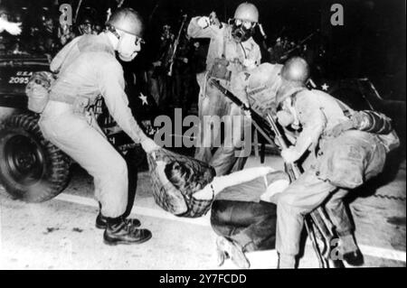 Des manifestants anti-guerre en conflit avec les gardes nationaux qui ont interrompu la Convention nationale démocratique. Photo : des gardes nationaux portant des masques à gaz et armés de fusils et de pistolets automatiques traînent un manifestant abattu après avoir franchi la barrière de police. Chicago, Illinois, États-Unis - 29 août 1968 Banque D'Images