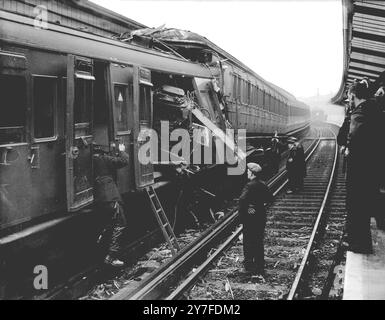 Les lignes sont bloquées après le crash ferroviaire de Woolwich. Les lignes montantes et descendantes ont été parsemées d'épaves et le service a été suspendu quand un train de Charing Cross à Dartford a couru à l'arrière d'un train de Cannon Street à Gravesend stationné à Woolwich Arsenal Station, Londres à 12 h 53. Deux personnes ont été tuées et deux autres blessées. Les deux trains de voyageurs, ils ne sont normalement pas bondés à cette heure-là. Images montrant, pompiers et sauveteurs fouillant l'extrémité de l'épave d'un des autocars après l'accident - autocars vus immédiatement après l'accident. 18 novembre 1948.. Banque D'Images