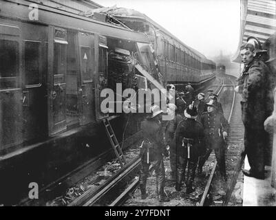 Les lignes sont bloquées après le crash ferroviaire de Woolwich. Les lignes montantes et descendantes ont été parsemées d'épaves et le service a été suspendu quand un train de Charing Cross à Dartford a couru à l'arrière d'un train de Cannon Street à Gravesend stationné à Woolwich Arsenal Station, Londres à 12 h 53. Deux personnes ont été tuées et deux autres blessées. Les deux trains de voyageurs, ils ne sont normalement pas bondés à cette heure-là. Photos montrant des pompiers et des secouristes fouillant l'extrémité de l'épave de l'un des autocars après l'accident. 18 novembre 1948.. Banque D'Images