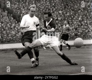 Angleterre - Écosse le capitaine de l'Angleterre Billy Wright (maillot blanc), jouant dans son 100e match international de football, remporte un duel pour le ballon avec l'écossais extérieur droit Graham Leggat à Wembley cet après-midi (Saterday). 11 avril 1959 Banque D'Images