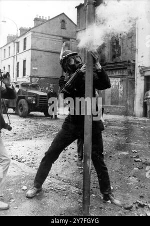 Un officier de police de la RUC tire un pistolet lacrymogène sur des émeutiers au sommet d'un bloc d'appartements dans la région de Bogside lors d'émeutes de masse déclenchées par un défilé des apprentis garçons pour marquer l'anniversaire du siège de Derry en 1689. Londonderry - 13 août 1969 Banque D'Images