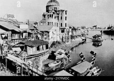 Une image dominée par la salle d'exposition industrielle en ruine - une scène de Hirsoshima, rasée par la première bombe atomique du monde explosée le 6 août 1945 la salle a été laissée dans son état en ruine 9 ans plus tard tandis que la ville est reconstruite et les bateaux et les gens retournent à leur vie le 6 août 1954 Banque D'Images