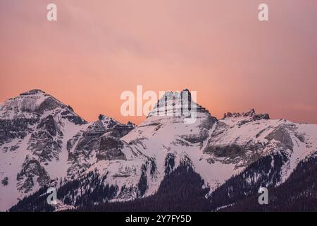 ciel rose au lever du soleil derrière les sommets enneigés des montagnes Banque D'Images