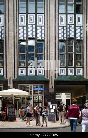 Les visiteurs explorent la cour Art Nouveau distinctive du Hackeschen Höfe à Berlin, entourée de décors uniques en céramique vitrée. Banque D'Images