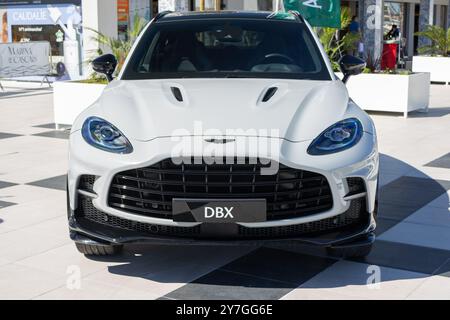 Vue de face d'un vus aston martin DBX blanc garé sur un motif à carreaux, mettant en valeur son design luxueux Banque D'Images