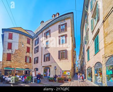 BERGAME, ITALIE - 7 AVRIL 2022 : les petits restaurants et cafés en plein air au milieu des maisons sur la via Bartolomeo Colleoni, Bergame, Lombardie, Italie Banque D'Images