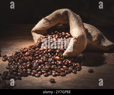 Grains de café débordant d'un sac en lin naturel Banque D'Images