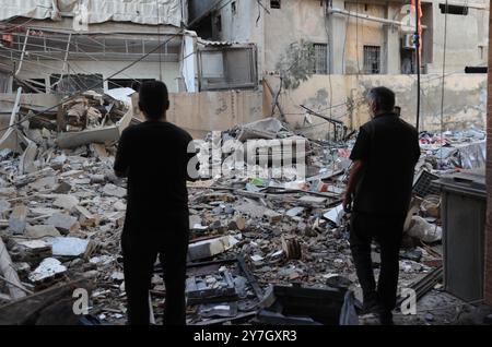 Beyrouth, Liban. 30 septembre 2024. Les gens vérifient les dommages causés par les frappes aériennes israéliennes dans la banlieue sud de Beyrouth, Liban, le 30 septembre 2024. Au moins 105 personnes ont été tuées et 359 autres blessées dimanche dans des frappes aériennes israéliennes sur le Liban, selon le ministère libanais de la santé. Crédit : Bilal Jawich/Xinhua/Alamy Live News Banque D'Images