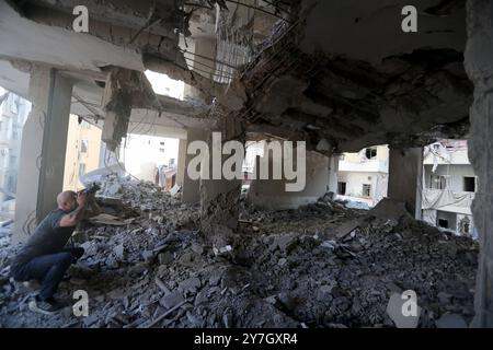 Beyrouth, Liban. 30 septembre 2024. Un homme prend des photos des dommages causés par les frappes aériennes israéliennes dans la banlieue sud de Beyrouth, Liban, le 30 septembre 2024. Au moins 105 personnes ont été tuées et 359 autres blessées dimanche dans des frappes aériennes israéliennes sur le Liban, selon le ministère libanais de la santé. Crédit : Bilal Jawich/Xinhua/Alamy Live News Banque D'Images