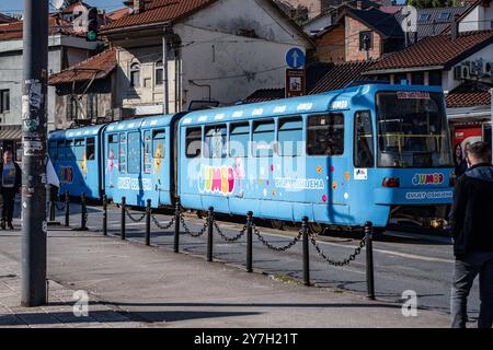 Blaue Straßenbahn à Sarajevo 21.09.24, Sarajevo : Symbolfoto, Illustrationsbild, Symbolbild, Illustrationsfoto, Alltagsszene Blaue Straßenbahn in Sarajevo Eine farbenfrohe blaue Straßenbahn fährt durch die Straßen von Sarajevo. Die Bahn ist mit einem bunten Jumbo-Design und dem Schriftzug Svijet Osmijeha Welt des Lächelns dekoriert. Passanten schlendern entlang der Straße, während die Bahn durch die Stadt fährt. . Sarajevo Hessen Bosnien-Herzegovine *** tramway bleu à Sarajevo 21 09 24, Sarajevo symbole photo, illustration image, symbole image, illustration photo, scène quotidienne Blue Street Banque D'Images