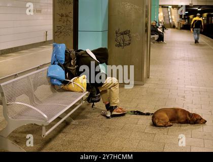 Berlin, Allemagne. 28 septembre 2024. 28.09.2024, Berlin. Un sans-abri dort assis sur un banc dans la station de S-Bahn Anhalter Bahnhof, tenant un chien en laisse pendant qu'il dort. Crédit : Wolfram Steinberg/dpa crédit : Wolfram Steinberg/dpa/Alamy Live News Banque D'Images