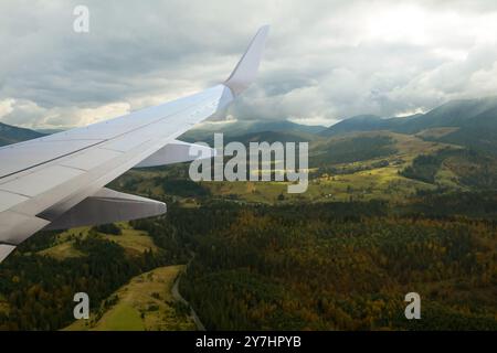 Avion volant au-dessus des montagnes, belle vue depuis la fenêtre Banque D'Images