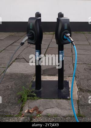 Stations de recharge de véhicules électriques modernes sur le trottoir urbain Banque D'Images