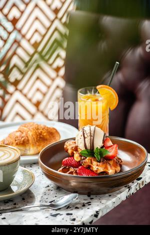 Gaufres américaines avec crème glacée, fraises, sirop d'érable et pépites de chocolat noir. Banque D'Images