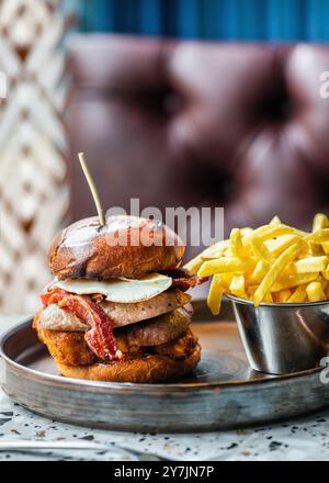 Hamburger aux œufs de gros bacon avec frites et boisson. Banque D'Images