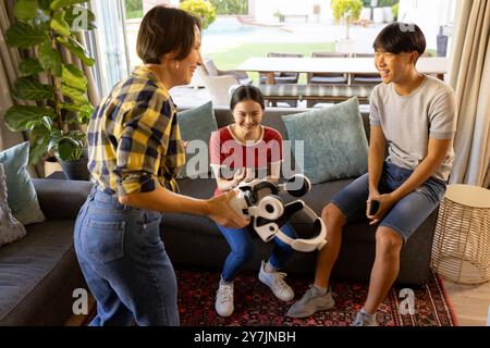 Jouer avec un casque VR, la famille profitant du temps ensemble dans le salon Banque D'Images