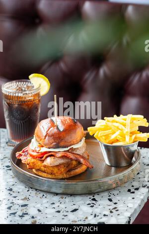 Hamburger aux œufs de gros bacon avec frites et boisson. Banque D'Images