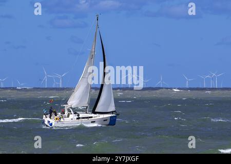 Voilier naviguant le long des éoliennes du parc éolien Borssele dans la mer du Nord à Westkapelle, Zeeland, pays-Bas sur une journée venteuse pendant la tempête d'automne Banque D'Images