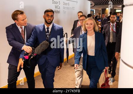 Birmingham, Royaume-Uni. 30 SEP, 2024. L'ancienne première ministre Liz Truss, flanquée de sécurité, marche vers l'hôtel Hyatt tandis que Sky News tente de l'interviewer le deuxième jour de la conférence du Parti conservateur de la CPI à Birmingham. Crédit Milo Chandler/Alamy Live News Banque D'Images