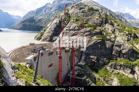 Guttannen, Suisse, 11 août 2024 : le nouveau barrage de Grimselsee se dresse devant l'ancien barrage. La construction du nouveau barrage est une fois par centur Banque D'Images