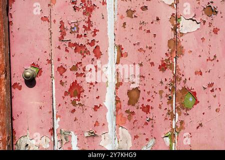 Peeling peinture de prédominance rouge et vert d'une porte. Banque D'Images