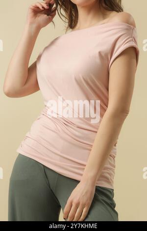 Mannequin féminin portant une chemise en coton doux rose pâle. Prise de vue en studio. Banque D'Images