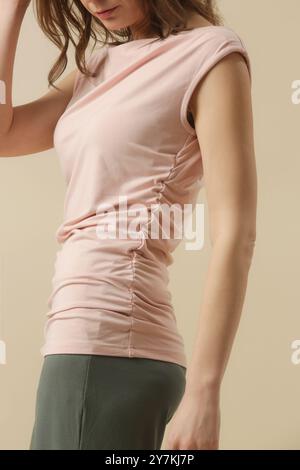 Mannequin féminin portant une chemise en coton doux rose pâle. Prise de vue en studio. Banque D'Images