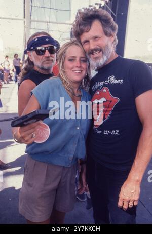 Manor, Texas, États-Unis. 30 septembre 2024. L'auteur-compositeur et acteur texan KRIS KRISTOFFERSON pose avec un fan alors que la légende WILLIE NELSON regarde Farm Aid II à Manor Downs à l'extérieur d'Austin le 4 juillet 1986. Kristofferson se dirigeait vers une carrière militaire quand il commença à chanter et enregistrer à Nashville et devint l'un des auteurs-compositeurs bien-aimés du Texas. Kristofferson est décédé le 28 septembre 2024 à Hawaï. (Crédit image : © Bob Daemmrich/ZUMA Press Wire) USAGE ÉDITORIAL SEULEMENT! Non destiné à UN USAGE commercial ! Banque D'Images