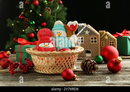Délicieux biscuits en forme de bonhommes de neige et décor de Noël sur table en bois Banque D'Images