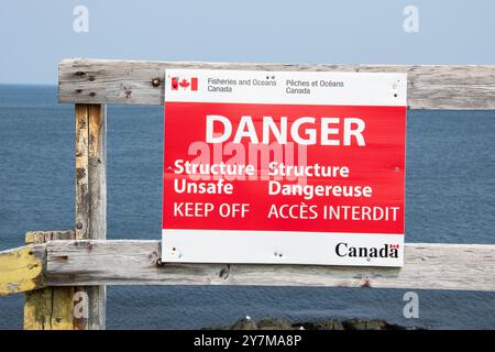 Pêches et Océans panneau de danger pour le bateau de pêche et le hangar abandonnés délabrés à Pouch Cove, Terre-Neuve-et-Labrador, Canada Banque D'Images