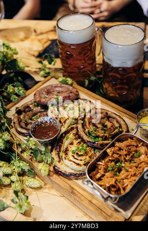 Saucisses allemandes traditionnelles accompagnées de bières, idéales pour l'Oktoberfest, la cuisine allemande et les thèmes du menu de pub Banque D'Images