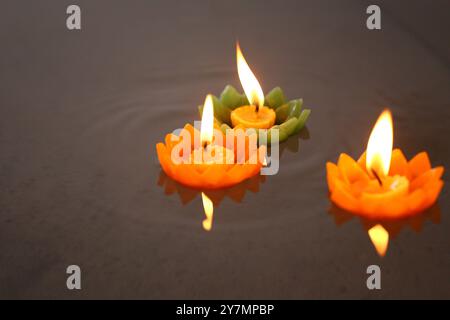 Bougies de Krathong avec des flammes flottant sur l'eau, Un rituel bouddhiste qui est censé enlever les mauvaises choses de la vie quand les bougies flottent. Banque D'Images