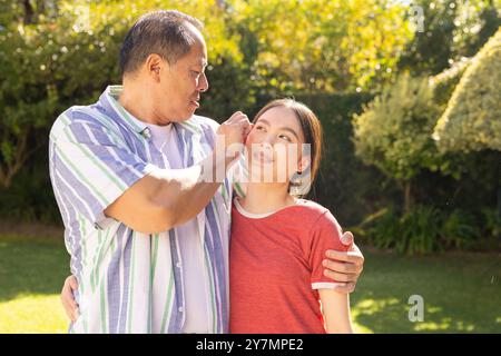 père et fille asiatiques se liant à l'extérieur, souriant et profitant de moments de qualité ensemble Banque D'Images
