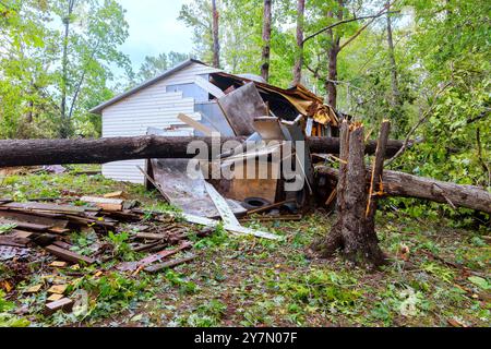 L'ouragan de tempête a déraciné des arbres qui sont tombés sur le hangar à cause des vents violents Banque D'Images
