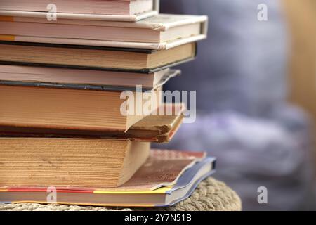 Une pile de livres assortis représentant l'apprentissage et l'éducation avec une atmosphère chaleureuse et accueillante en arrière-plan. Banque D'Images