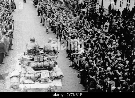 Les survivants acclamés saluent les troupes américaines alors que les premiers chars alliés entrent dans le camp de concentration de Mauthausen. Cette photo était une reconstitution de l'événement réel qui n'avait pas été photographié. Mauthausen était un camp de travaux forcés nazi, faisant partie du complexe de Mauthausen. À son apogée, il y avait 85 000 prisonniers à la fois. Il était tristement célèbre pour sa dureté - on estime que sur les 190 000 prisonniers détenus pendant ses opérations, la moitié est morte. Il abritait la carrière de Wiener Graben et ses redoutables escaliers de la mort (Todessteige) où beaucoup moururent en transportant d'énormes charges sur les 186 marches de pierre. Banque D'Images