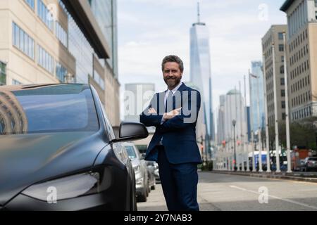 Dealer Man en costume cher. Homme d'affaires loue une voiture. Agent d'assurance chez voiture de luxe. Concessionnaire automobile prospère. Concessionnaire automobile. Assurance automobile Banque D'Images