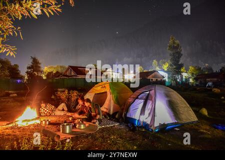 Pahalgam, Inde. 30 septembre 2024. Les visiteurs se rassemblent autour d'un feu de joie sous le ciel étoilé de la nuit à Pahalgam, une station de colline à environ 120kms de Srinagar la capitale estivale du Jammu-et-Cachemire. Crédit : SOPA images Limited/Alamy Live News Banque D'Images