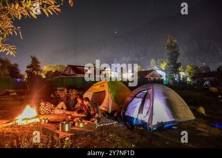 Pahalgam, Inde. 30 septembre 2024. Les visiteurs se rassemblent autour d'un feu de joie sous le ciel étoilé de la nuit à Pahalgam, une station de colline à environ 120kms de Srinagar la capitale estivale du Jammu-et-Cachemire. (Photo de Saqib Majeed/SOPA images/Sipa USA) crédit : Sipa USA/Alamy Live News Banque D'Images