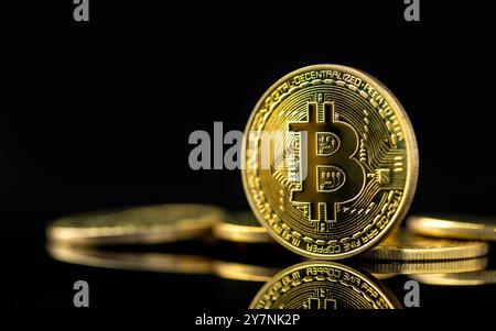 Bitcoin sur fond sombre, gros plan bitcoin doré une monnaie numérique, fonctionne sur un système décentralisé avec des transactions enregistrées et de nouvelles unités cr Banque D'Images