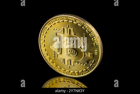 Bitcoin sur fond sombre, gros plan bitcoin doré une monnaie numérique, fonctionne sur un système décentralisé avec des transactions enregistrées et de nouvelles unités cr Banque D'Images