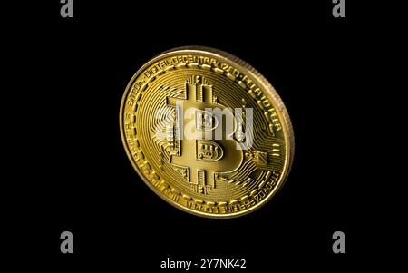 Bitcoin sur fond sombre, gros plan bitcoin doré une monnaie numérique, fonctionne sur un système décentralisé avec des transactions enregistrées et de nouvelles unités cr Banque D'Images