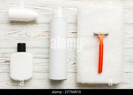 kit homme à raser. machine à raser, serviette, lotion et mousse à raser sur fond coloré. Articles de bain pour hommes vue du dessus. Banque D'Images