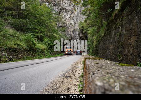 Fahrzeuge passieren eine enge Bergstraße in Vares, Bosnien 19.09.24, Vares : Symbolfoto, Illustrationsbild, Symbolbild, Illustrationsfoto, Alltagsszene Fahrzeuge passieren eine enge Bergstraße in Vares, Bosnien Ein LKW und ein auto fahren durch eine enge, kurvige Bergstraße in Vares, Bosnien, die durch massive Felswände und üppige Vegetation führt. Die Straße führt direkt in einen Felsentunnel, was die herausfordernde Infrastruktur und die natürliche Schönheit der Region hervorhebt. . Vares Hessen Bosnien-Herzegovine *** les véhicules traversent une étroite route de montagne à Vares, Bosnie 19 09 24, va Banque D'Images